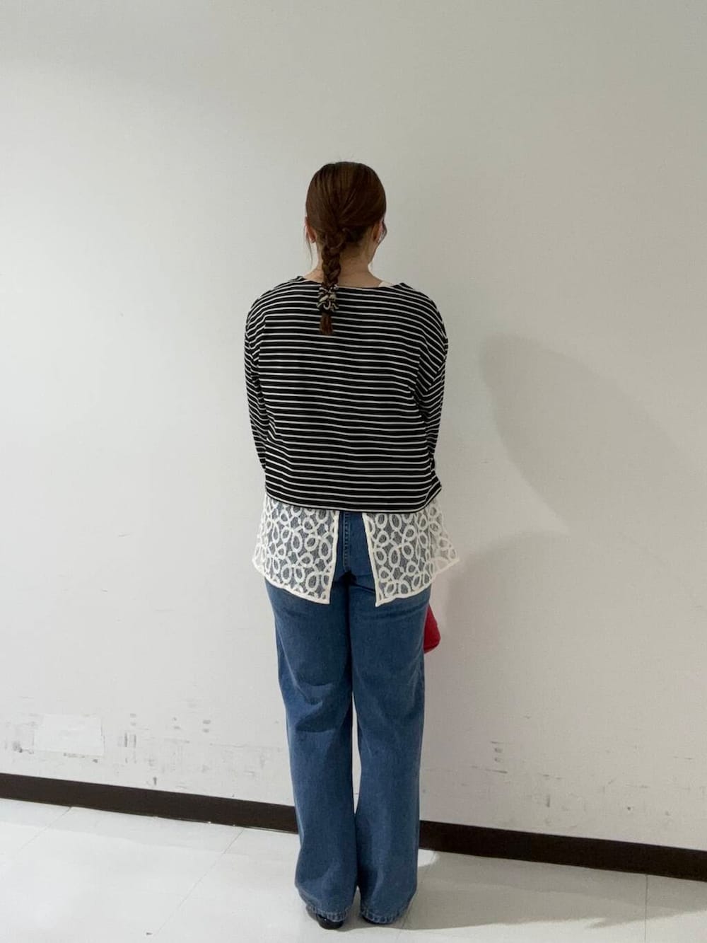 ブラック系のその他シューズ、ブルー系のデニムパンツ、レッド系のトートバッグを着用したレディースの夏コーディネートの3枚目の写真