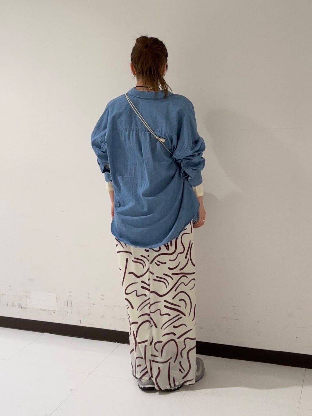 イエロー系のTシャツ/カットソー、ホワイト系のショルダーバッグ、レッド系のワンピースを着用したレディースの冬コーディネートの3枚目の写真