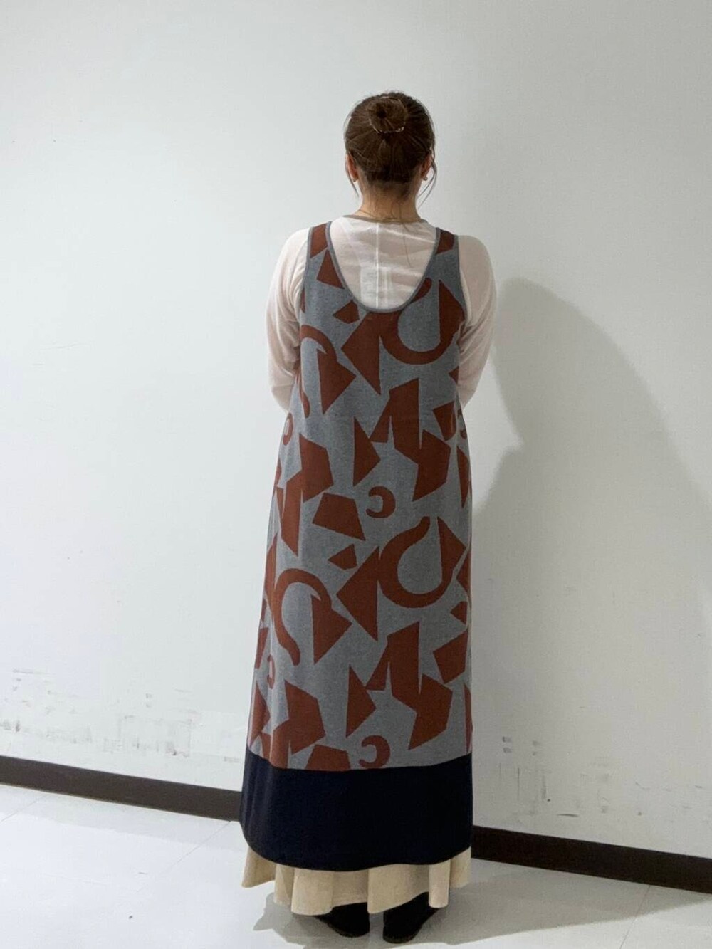 グレー系のTシャツ/カットソー、グレー系のニット/セーター、ブラック系のハンドバッグを着用したレディースの秋コーディネートの3枚目の写真