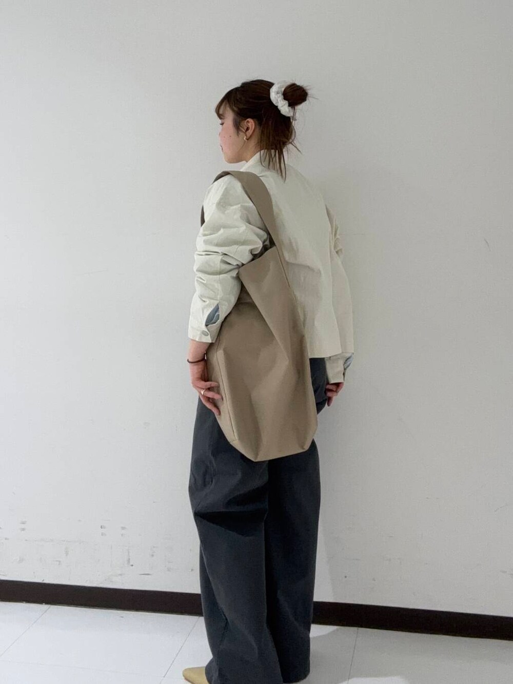 ベージュ系のパンプス、グレー系のその他パンツ、ホワイト系のブルゾンを着用したレディースの冬コーディネートの2枚目の写真