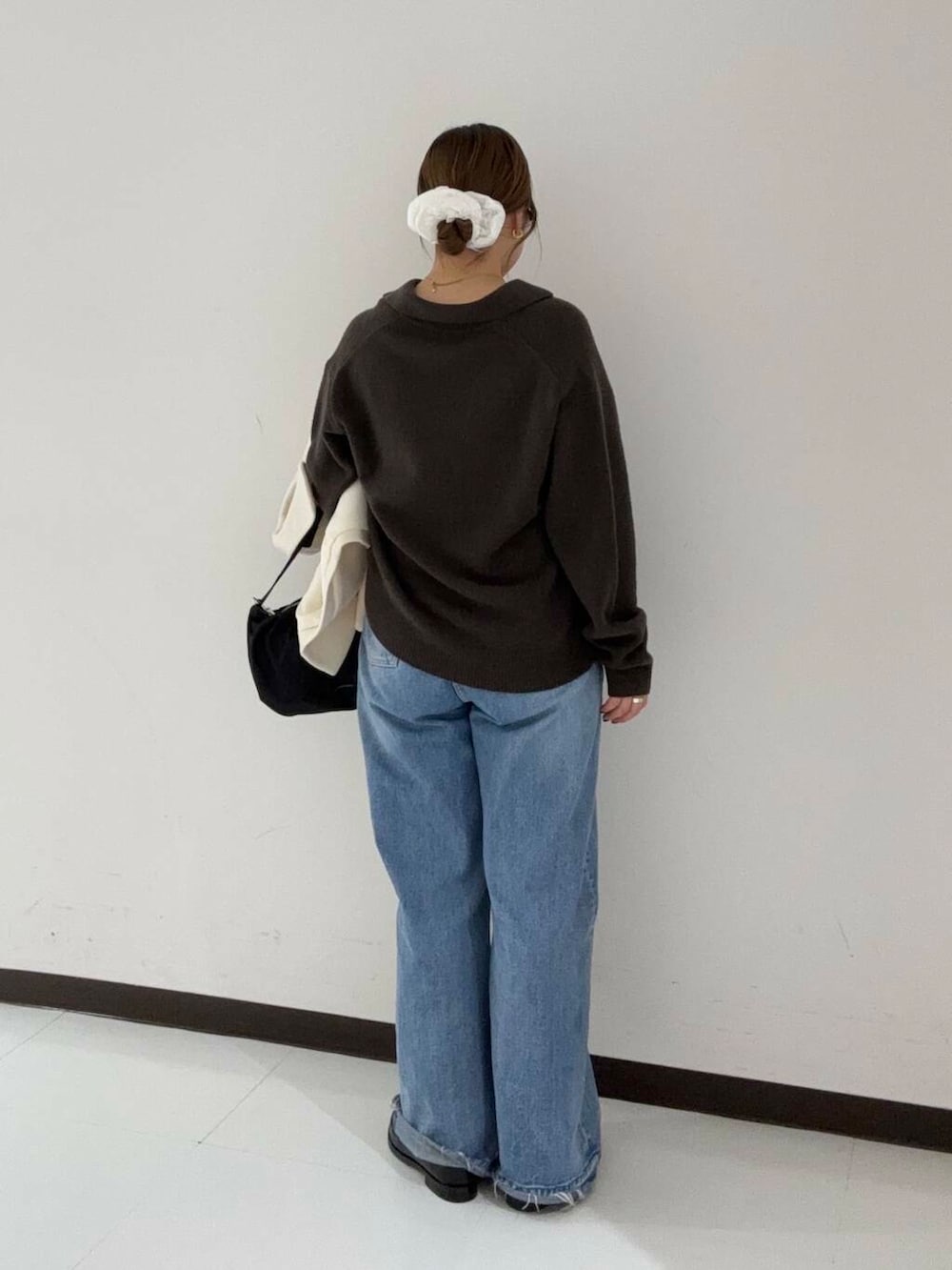 ブルー系のデニムパンツ、ブラウン系のニット/セーター、ホワイト系のその他アウターを着用したレディースの冬コーディネートの2枚目の写真