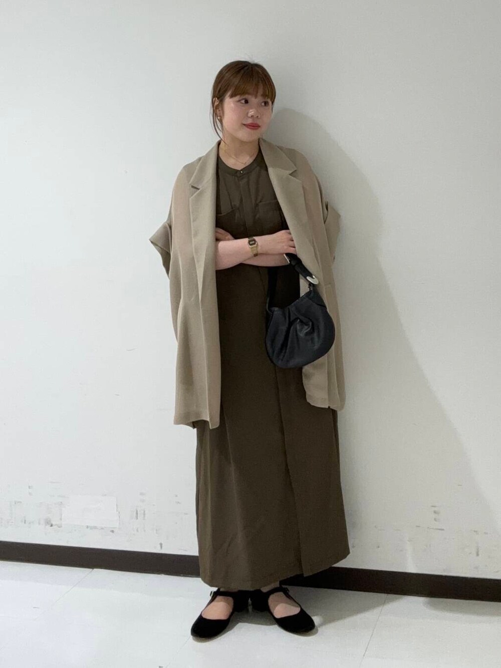 ベージュ系のテーラードジャケット、ブラウン系のワンピース、ブラック系のハンドバッグを着用したレディースの夏コーディネートの2枚目の写真