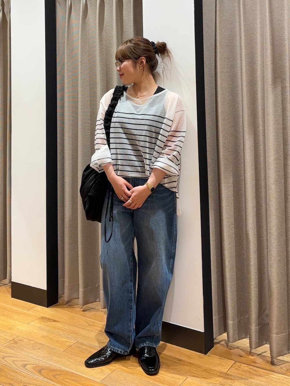 ブラック系のショルダーバッグ、ブラック系のローファー、ブルー系のデニムパンツを着用したレディースの夏コーディネートの3枚目の写真