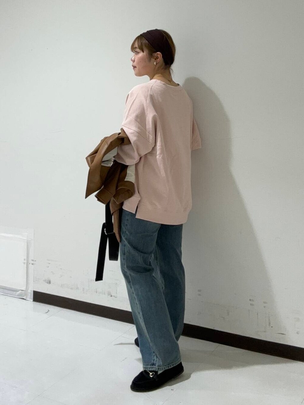 ブラック系のショルダーバッグ、イエロー系のブルゾン、ピンク系のTシャツ/カットソーを着用したレディースの秋コーディネートの2枚目の写真