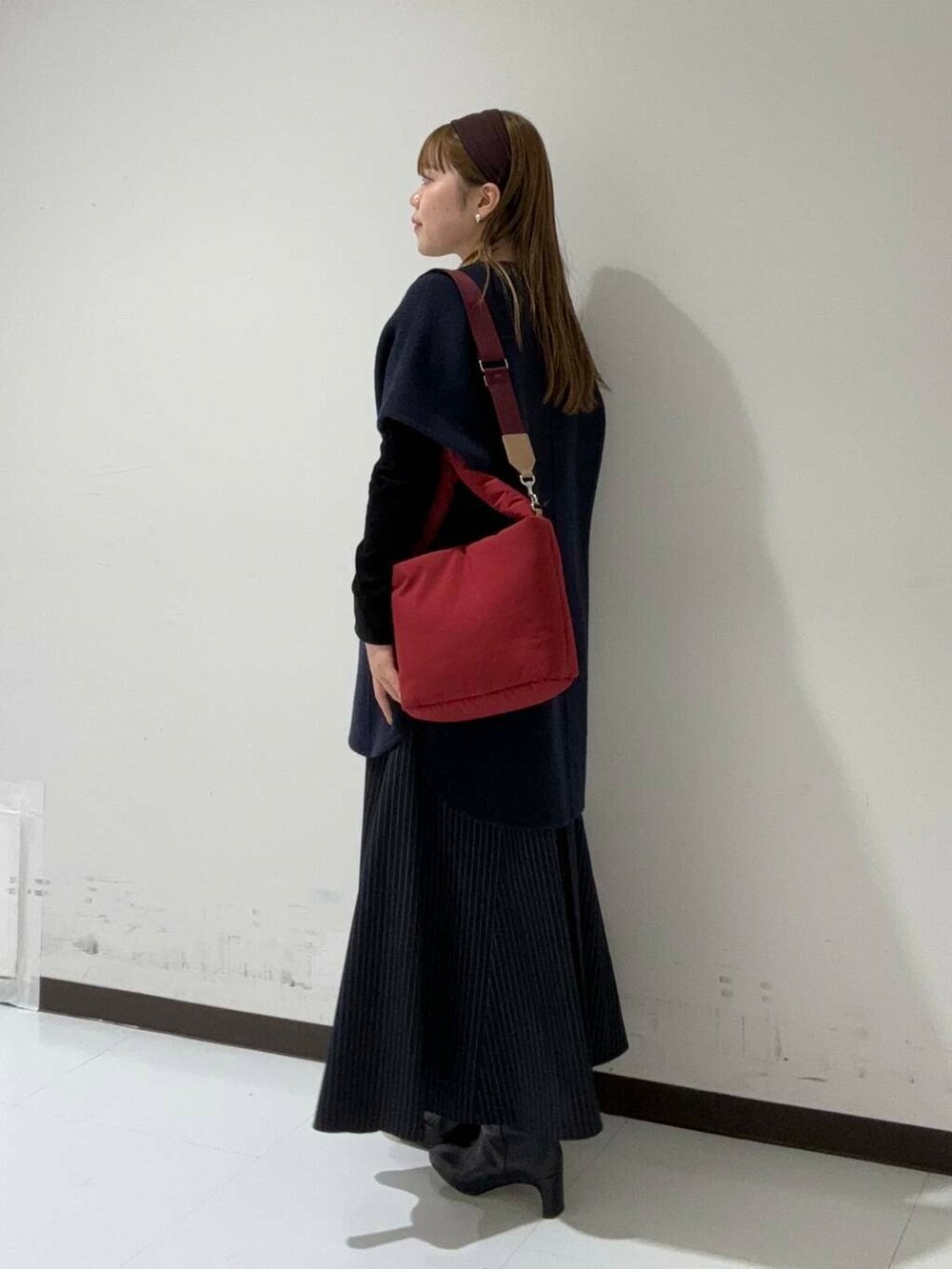 ブルー系のスカート、ブラック系のカーディガン/ボレロ、ブルー系のポンチョを着用したレディースの秋コーディネートの2枚目の写真