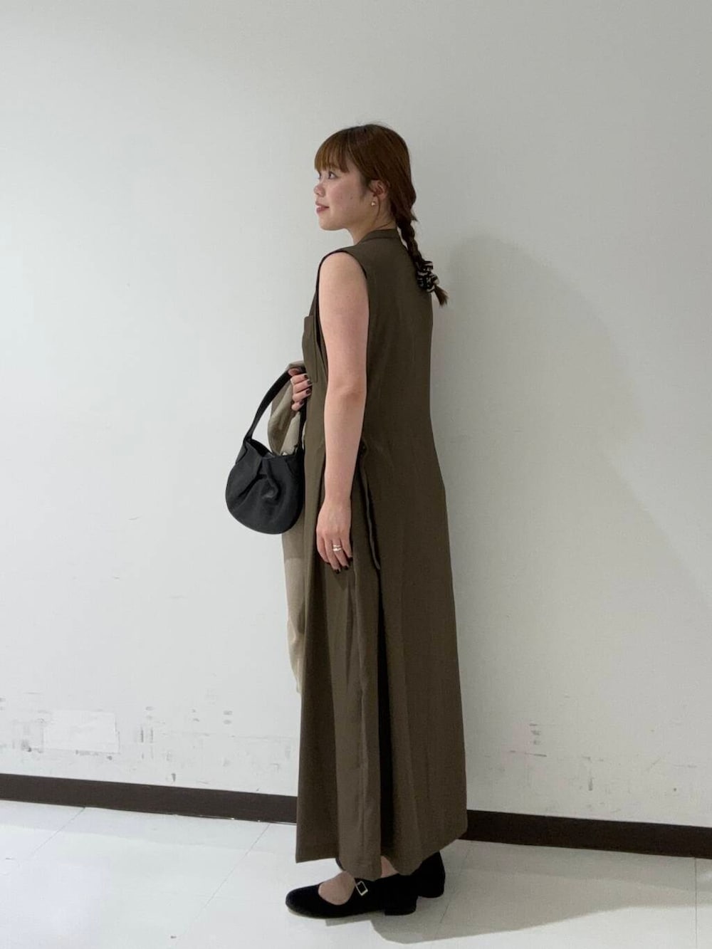 ベージュ系のテーラードジャケット、ブラウン系のワンピース、ブラック系のハンドバッグを着用したレディースの夏コーディネートの3枚目の写真