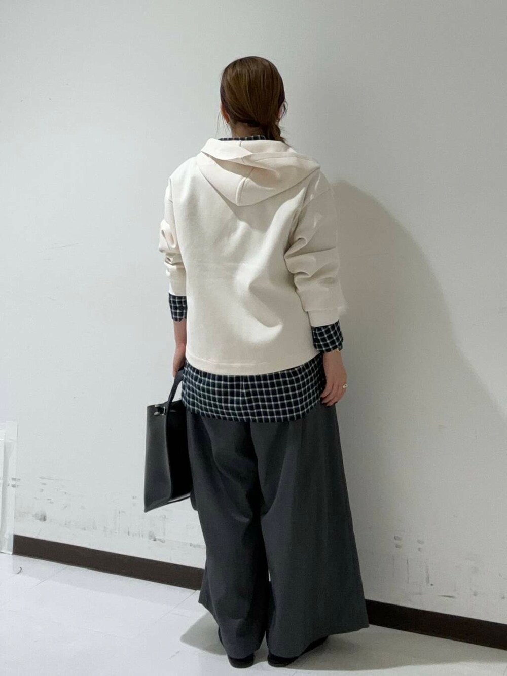 ブルー系のシャツ/ブラウス、ブラック系のトートバッグ、ホワイト系のブルゾンを着用したレディースの秋コーディネートの3枚目の写真