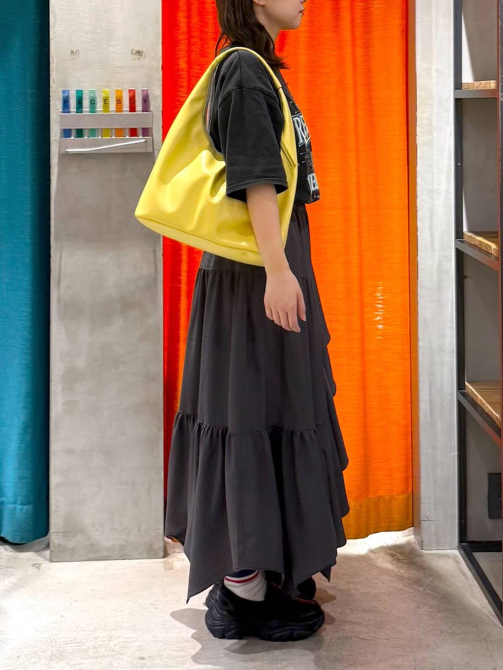 グレー系のスカート、イエロー系のトートバッグ、グレー系のTシャツ/カットソーを着用したレディースの春コーディネートの3枚目の写真