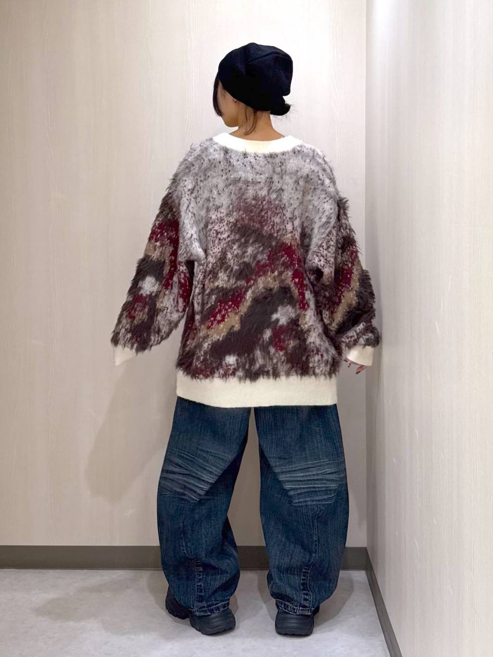 ブラック系のブーツ、ホワイト系のカーディガン/ボレロ、ブルー系のデニムパンツを着用したレディースの秋コーディネートの3枚目の写真