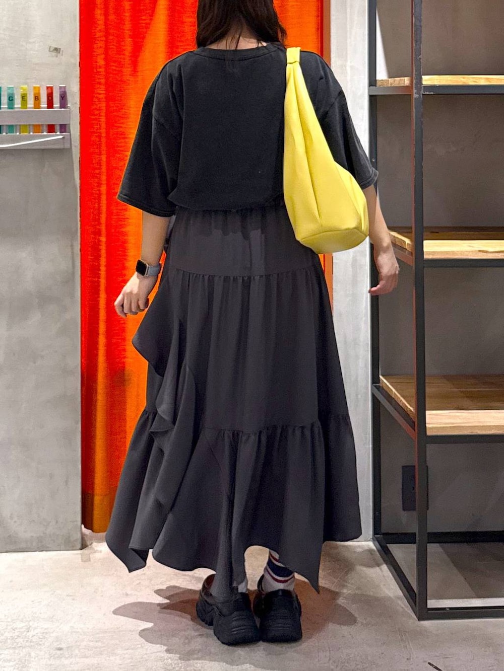 グレー系のスカート、イエロー系のトートバッグ、グレー系のTシャツ/カットソーを着用したレディースの春コーディネートの4枚目の写真