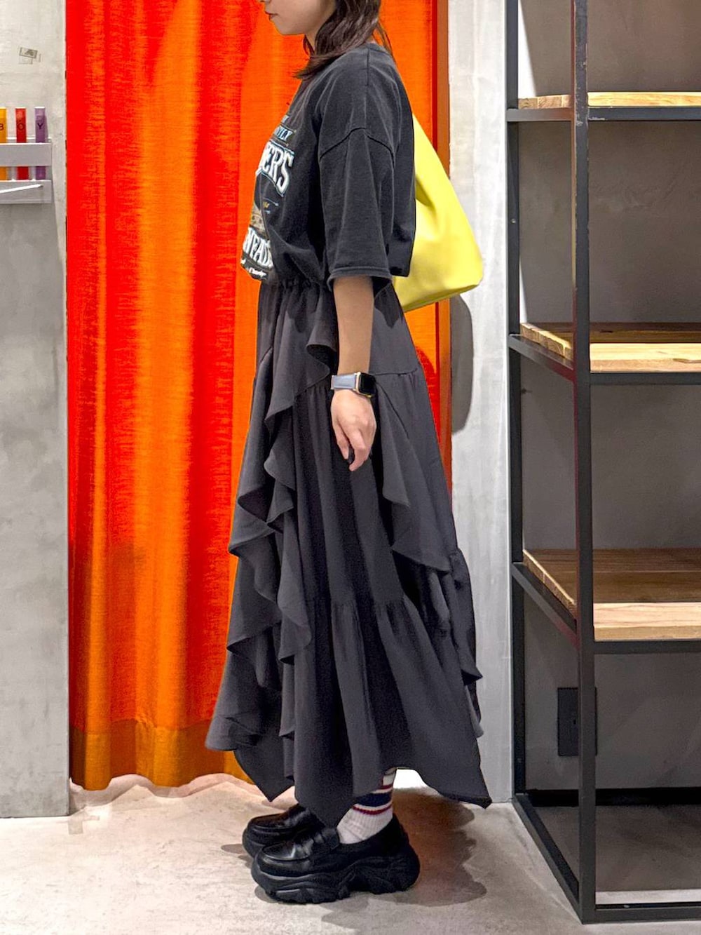 グレー系のスカート、イエロー系のトートバッグ、グレー系のTシャツ/カットソーを着用したレディースの春コーディネートの5枚目の写真