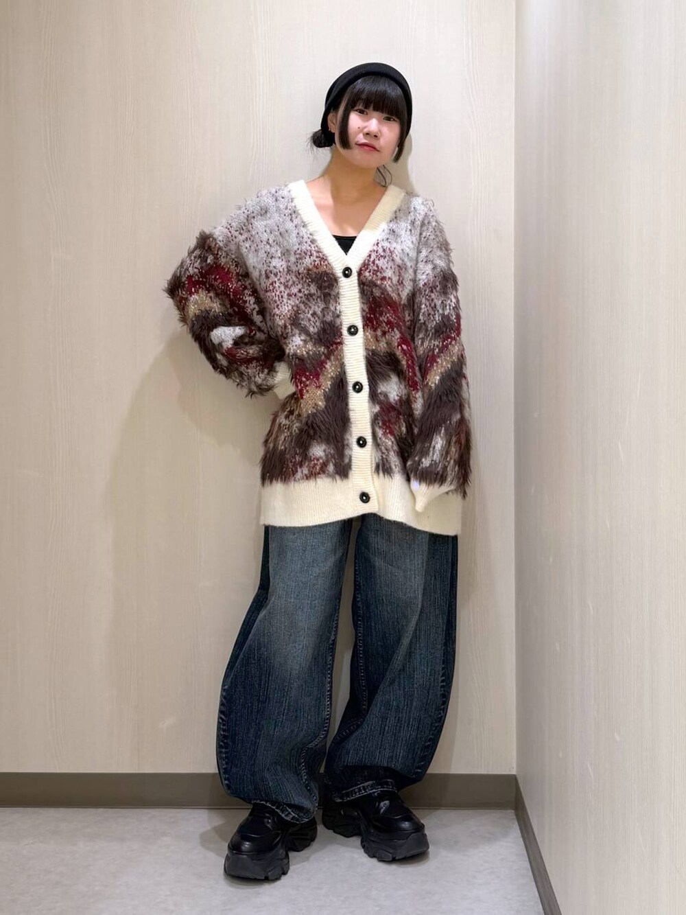 ブラック系のブーツ、ホワイト系のカーディガン/ボレロ、ブルー系のデニムパンツを着用したレディースの秋コーディネートの8枚目の写真