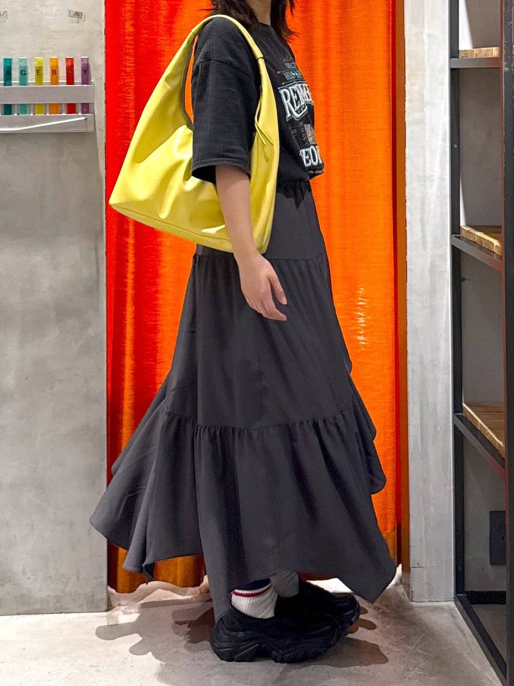 グレー系のスカート、イエロー系のトートバッグ、グレー系のTシャツ/カットソーを着用したレディースの春コーディネートの7枚目の写真