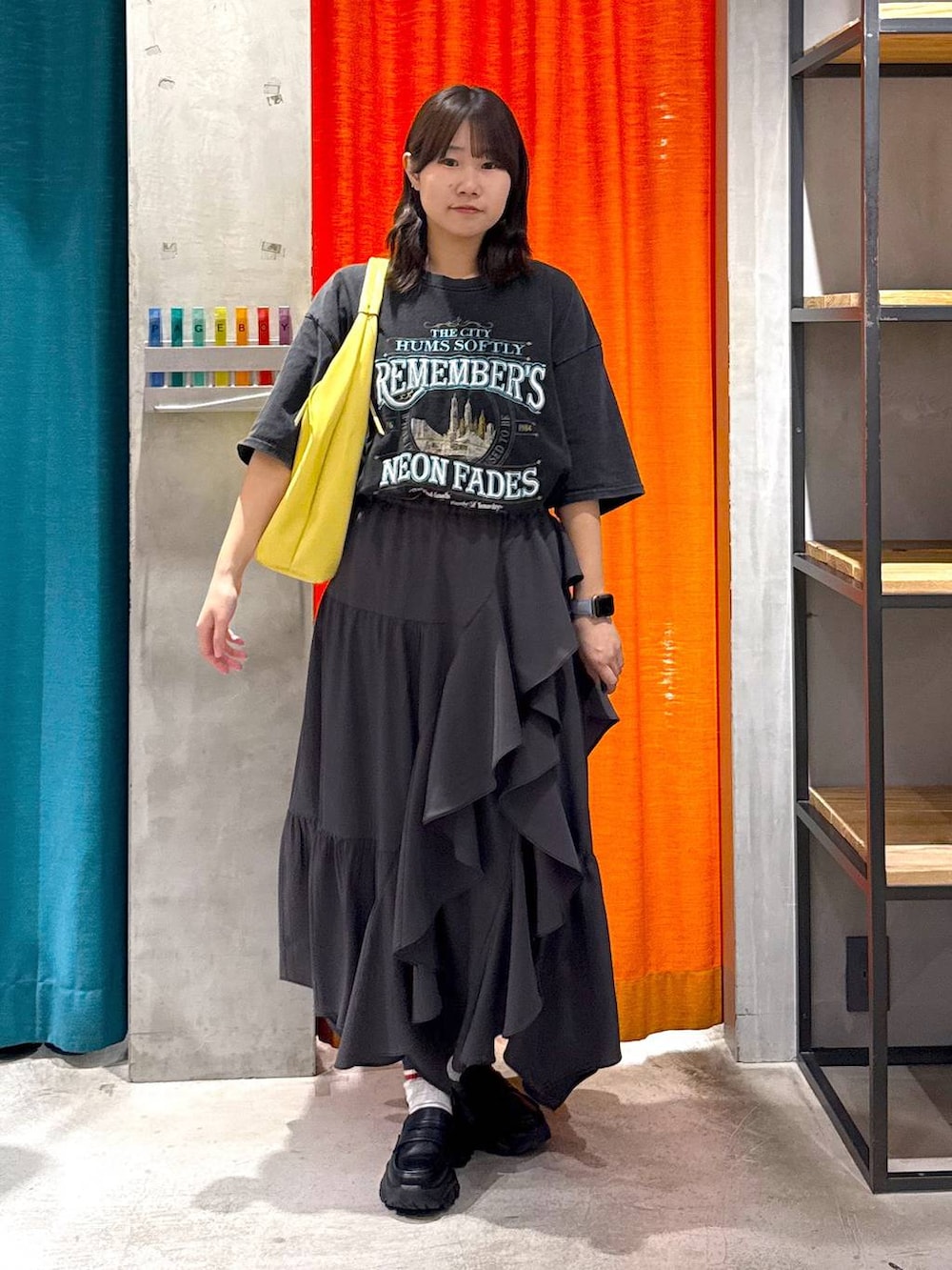 グレー系のスカート、イエロー系のトートバッグ、グレー系のTシャツ/カットソーを着用したレディースの春コーディネートの6枚目の写真