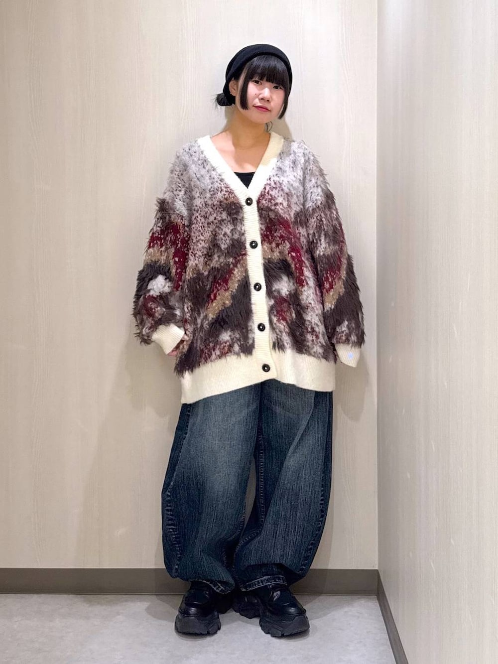 ブラック系のブーツ、ホワイト系のカーディガン/ボレロ、ブルー系のデニムパンツを着用したレディースの秋コーディネートの10枚目の写真