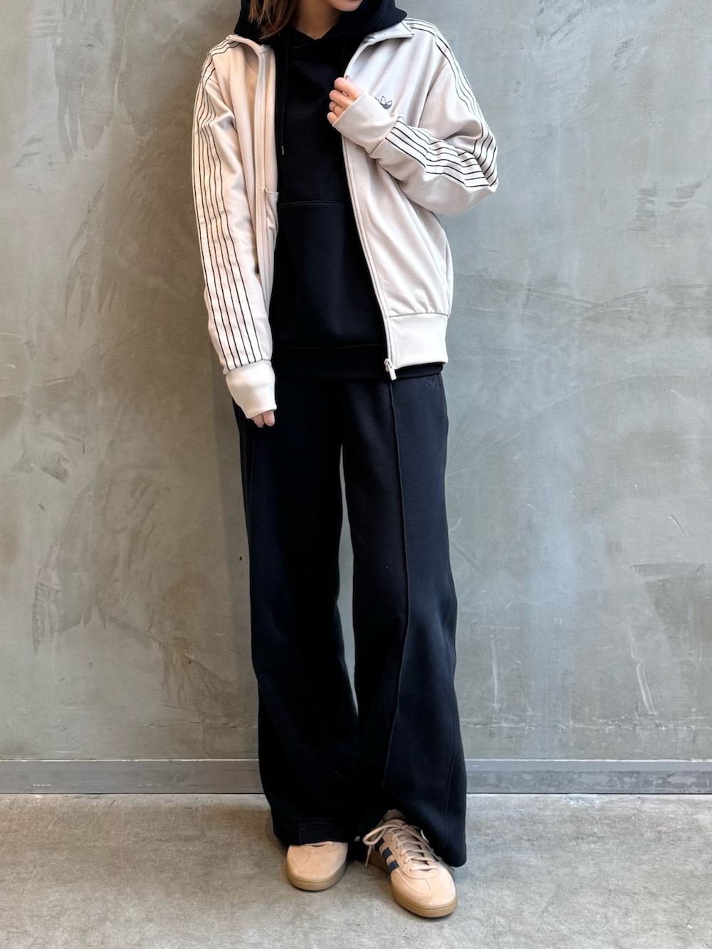 ベージュ系のジャージ、ベージュ系のスニーカー、ベージュ系のキャップを着用したレディースの冬コーディネートの2枚目の写真