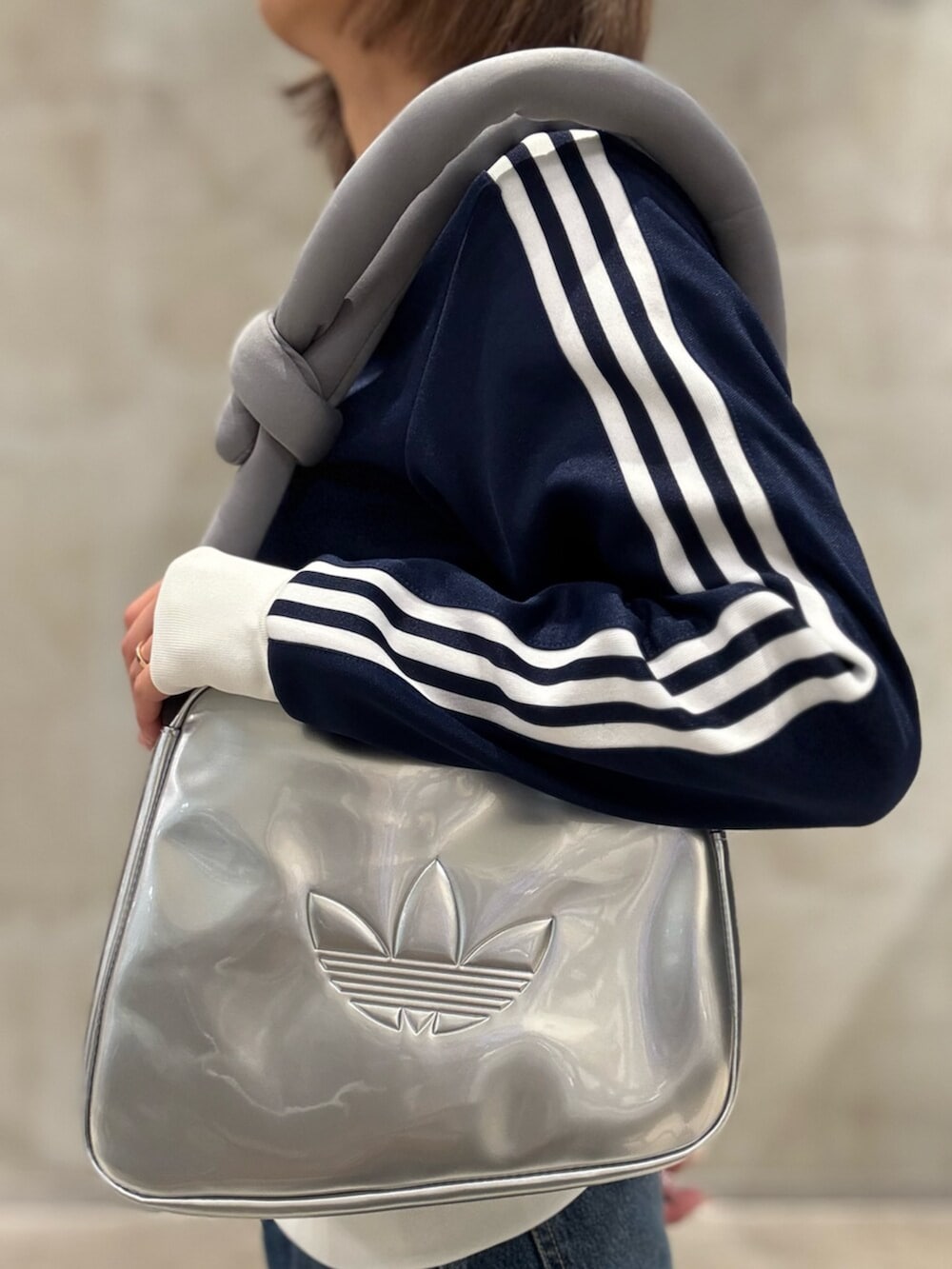 ブルー系のスニーカー、ブルー系のジャージ、シルバー系のショルダーバッグを着用したレディースの夏コーディネートの4枚目の写真