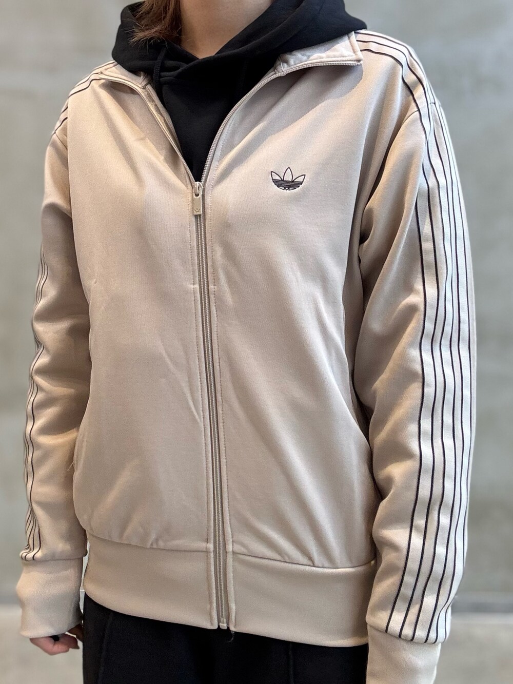 ベージュ系のジャージ、ベージュ系のスニーカー、ベージュ系のキャップを着用したレディースの冬コーディネートの4枚目の写真