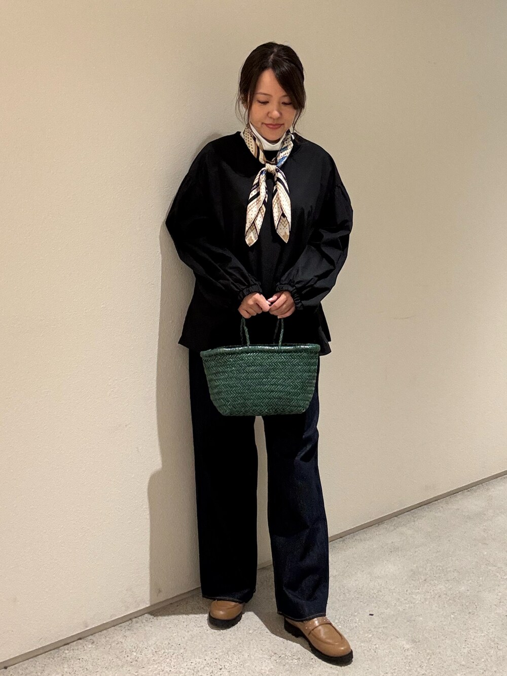 ブラック系のシャツ/ブラウス、ホワイト系のTシャツ/カットソー、ブルー系のデニムパンツを着用したレディースの秋コーディネートの4枚目の写真