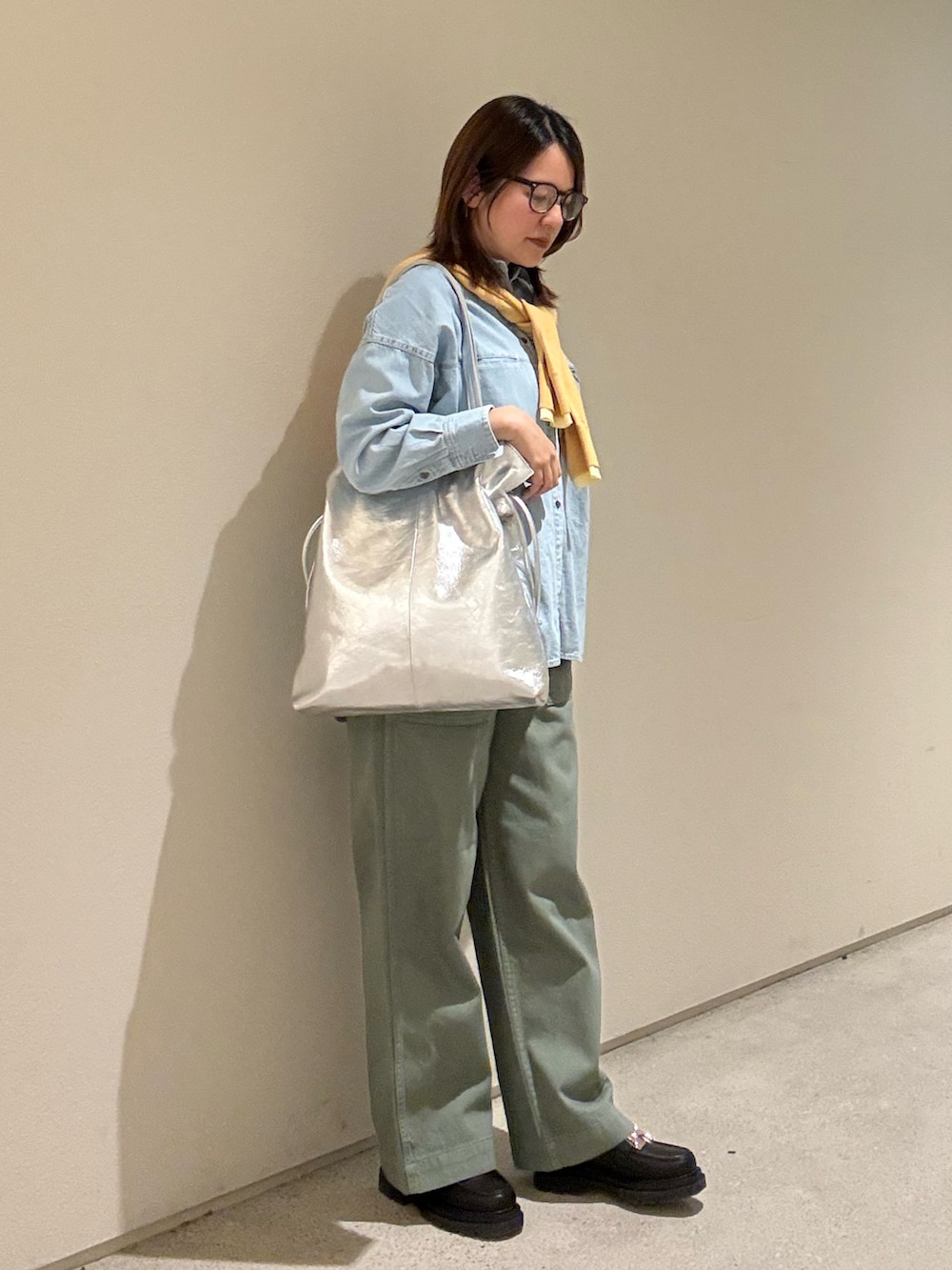 ブルー系のシャツ/ブラウス、オレンジ系のカーディガン/ボレロ、シルバー系のトートバッグを着用したレディースの春コーディネートの2枚目の写真