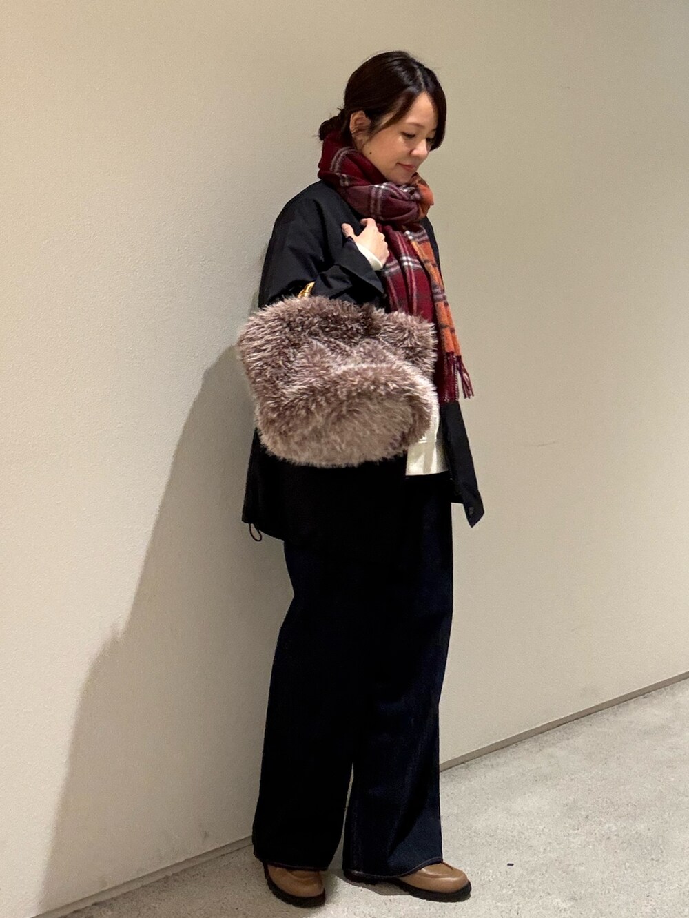 ホワイト系のスウェット、ブラック系のブルゾン、ブルー系のデニムパンツを着用したレディースの秋コーディネートの2枚目の写真