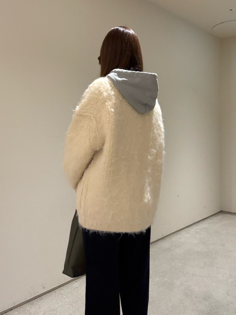 ブルー系のその他パンツ、ベージュ系のカーディガン/ボレロ、グリーン系のトートバッグを着用したレディースの冬コーディネートの4枚目の写真