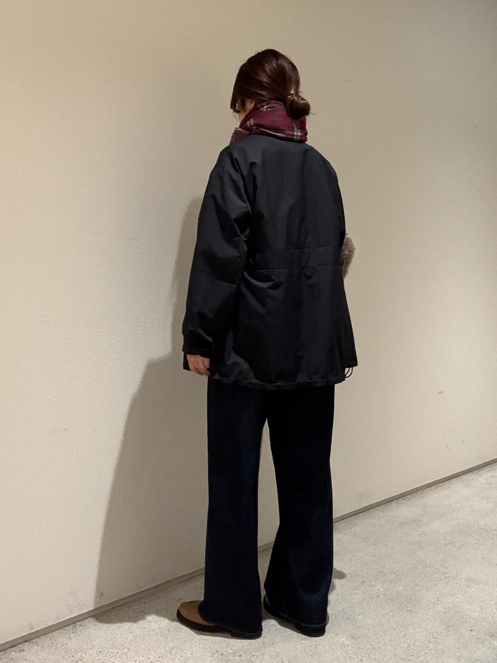 ホワイト系のスウェット、ブラック系のブルゾン、ブルー系のデニムパンツを着用したレディースの秋コーディネートの3枚目の写真