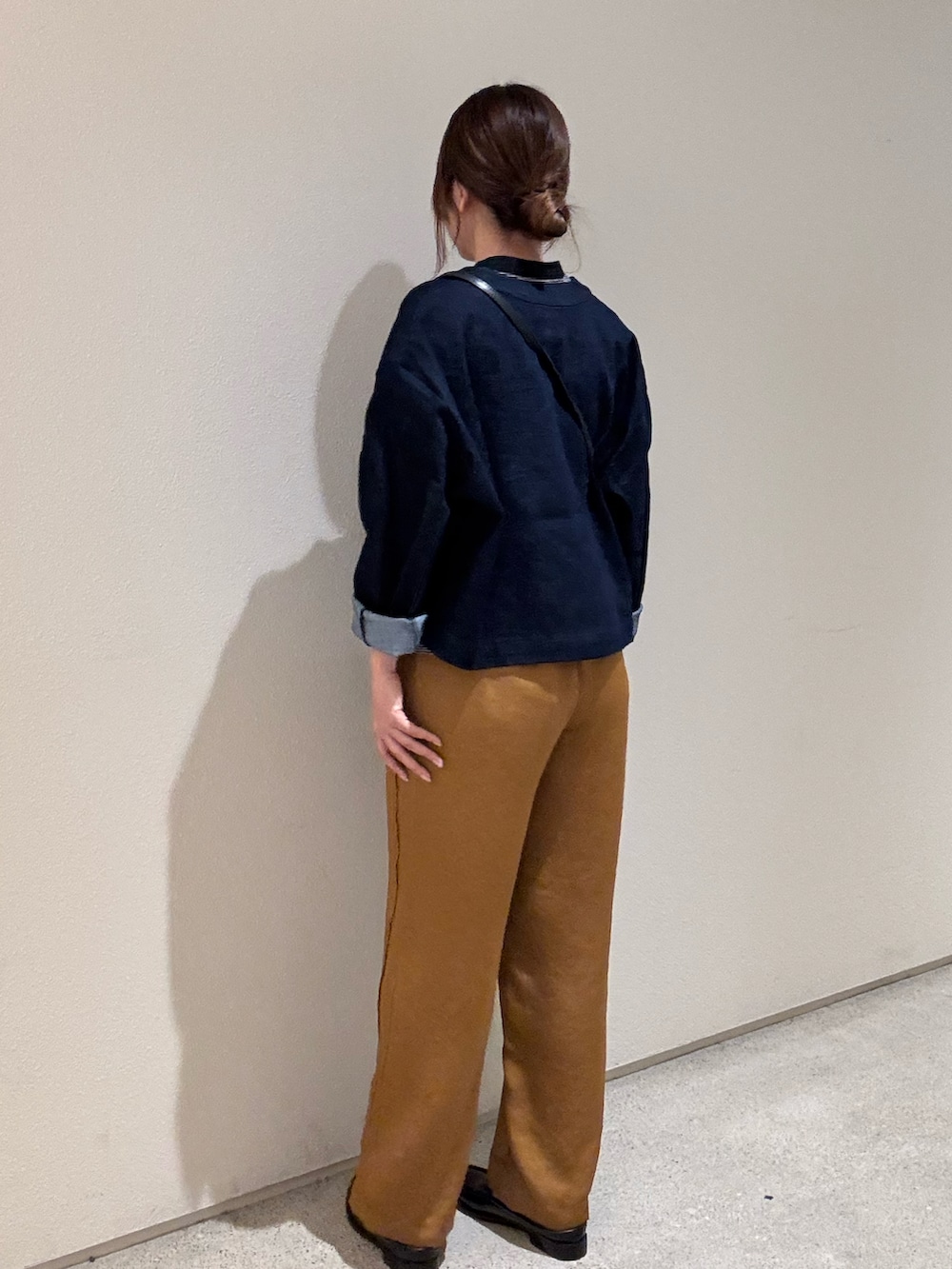 ブルー系のノーカラージャケット、ブラック系のTシャツ/カットソー、ブラック系のショルダーバッグを着用したレディースの秋コーディネートの2枚目の写真