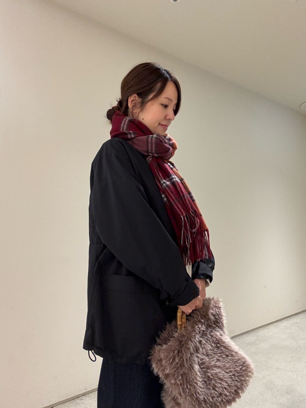 ホワイト系のスウェット、ブラック系のブルゾン、ブルー系のデニムパンツを着用したレディースの秋コーディネートの4枚目の写真