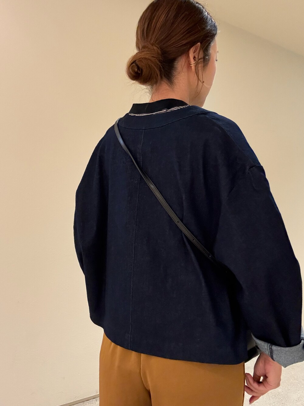 ブルー系のノーカラージャケット、ブラック系のTシャツ/カットソー、ブラック系のショルダーバッグを着用したレディースの秋コーディネートの3枚目の写真