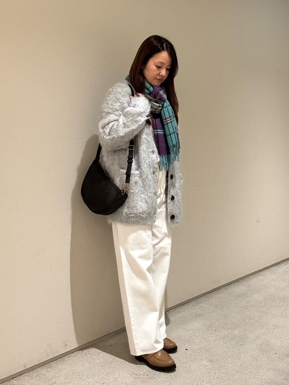 グレー系のカーディガン/ボレロ、ホワイト系のスウェット、ホワイト系のデニムパンツを着用したレディースの秋コーディネートの3枚目の写真