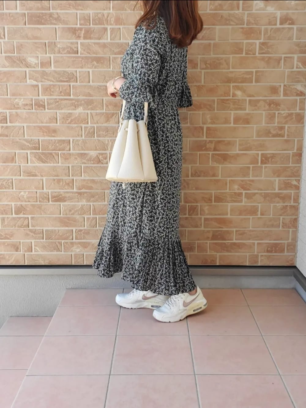 ブラック系のワンピース、ホワイト系のスニーカーを着用したレディースの春コーディネートの2枚目の写真