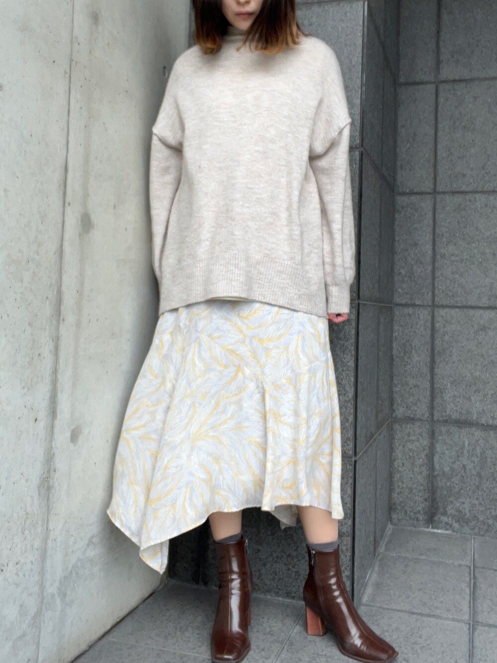 ベージュ系のニット/セーター、ホワイト系のTシャツ/カットソー、その他のスカートを着用したレディースの冬コーディネートの2枚目の写真