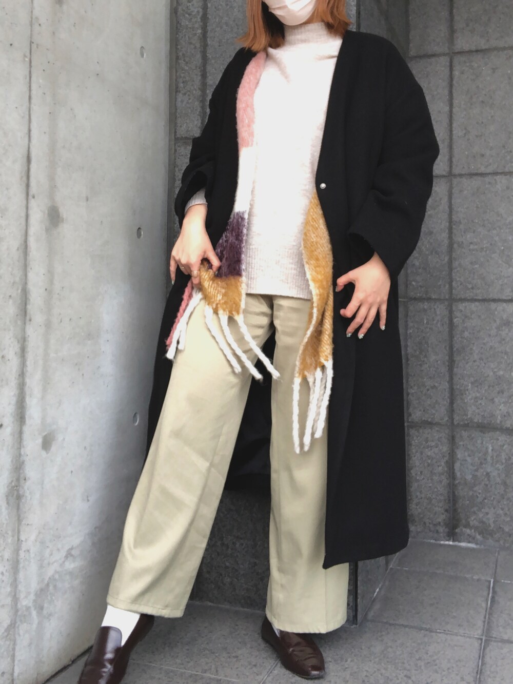 グリーン系のパンツ、ブラウン系のローファー、ベージュ系のニット/セーターを着用したレディースの冬コーディネートの3枚目の写真