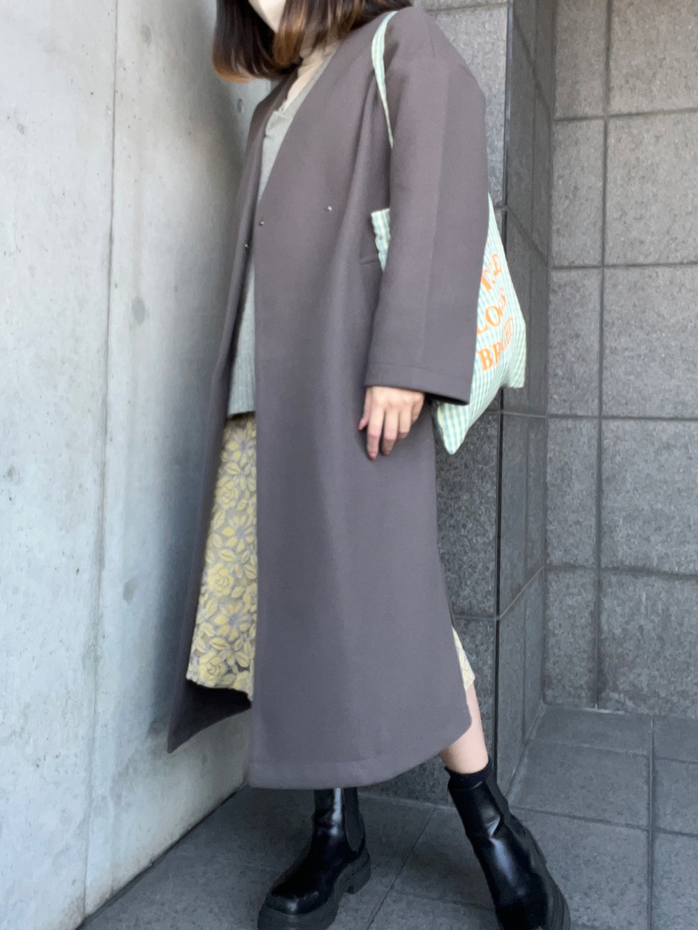 グリーン系のニット/セーター、グレー系のノーカラーコート、ホワイト系のニット/セーターを着用したレディースの冬コーディネートの3枚目の写真