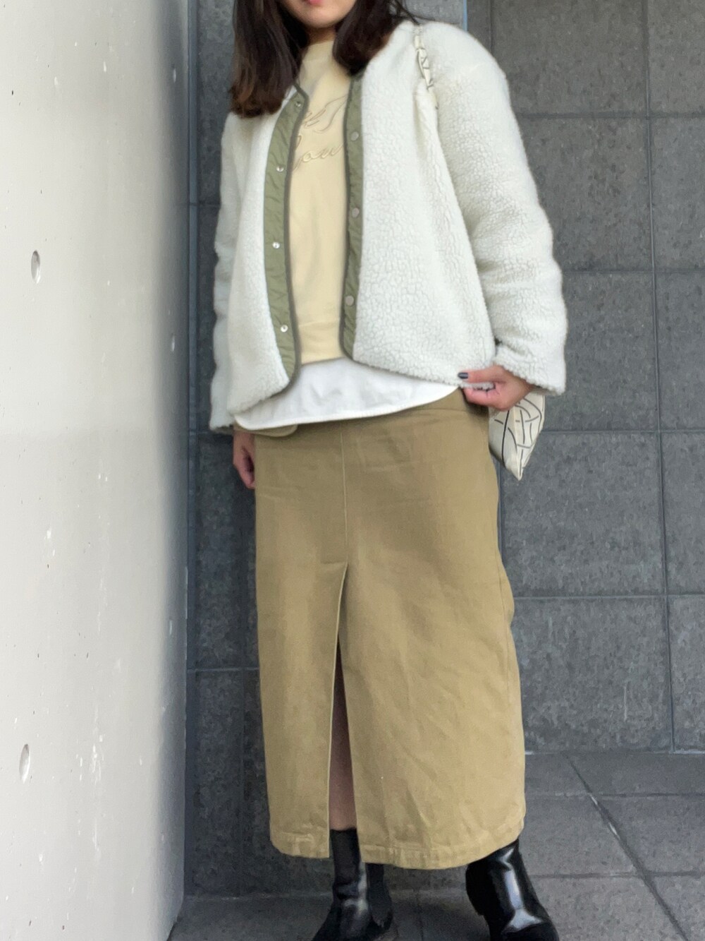 グリーン系のノーカラージャケット、イエロー系のスウェット、ホワイト系のTシャツ/カットソーを着用したレディースの冬コーディネートの2枚目の写真
