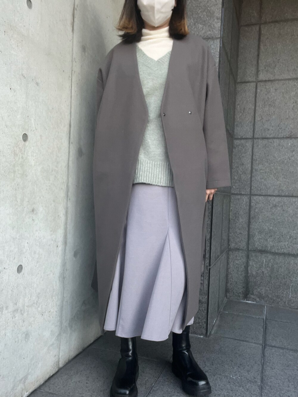 グリーン系のニット/セーター、ホワイト系のニット/セーター、ブルー系のスカートを着用したレディースの冬コーディネートの2枚目の写真