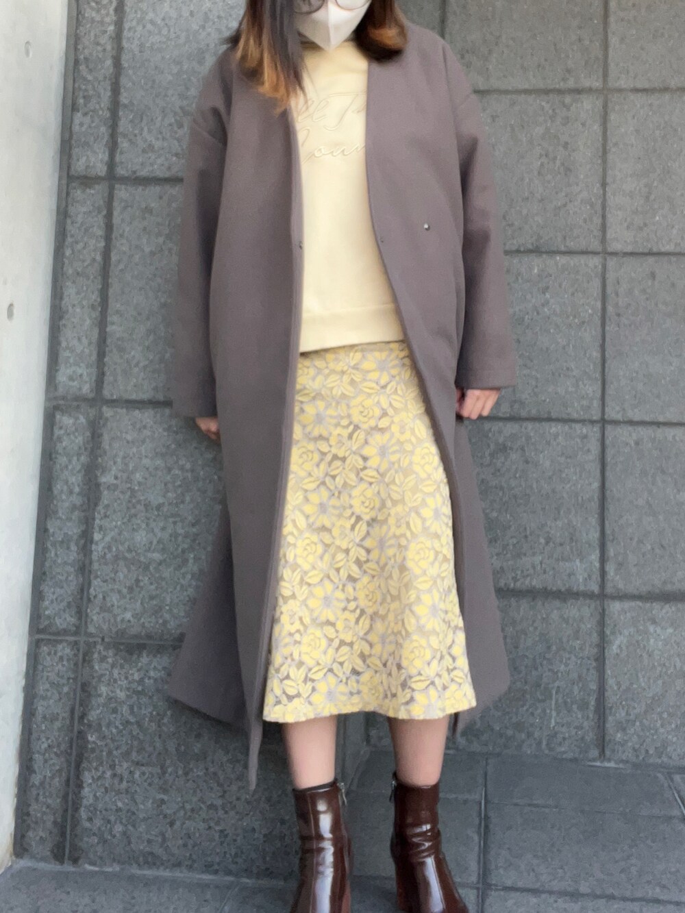 ホワイト系のニット/セーター、イエロー系のスウェット、イエロー系のスカートを着用したレディースの春コーディネートの2枚目の写真