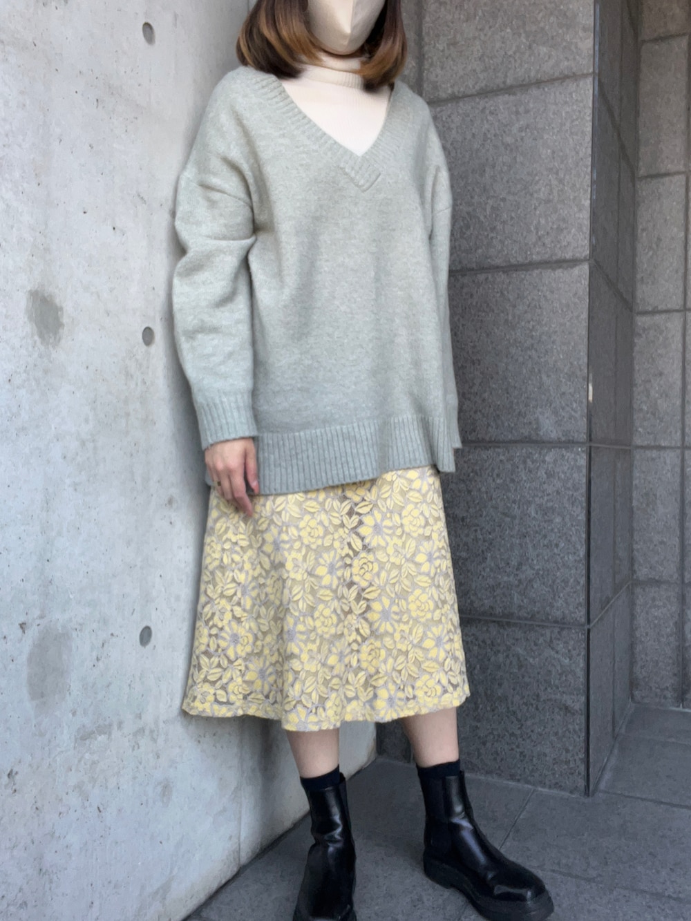 グリーン系のニット/セーター、グレー系のノーカラーコート、ホワイト系のニット/セーターを着用したレディースの冬コーディネートの2枚目の写真