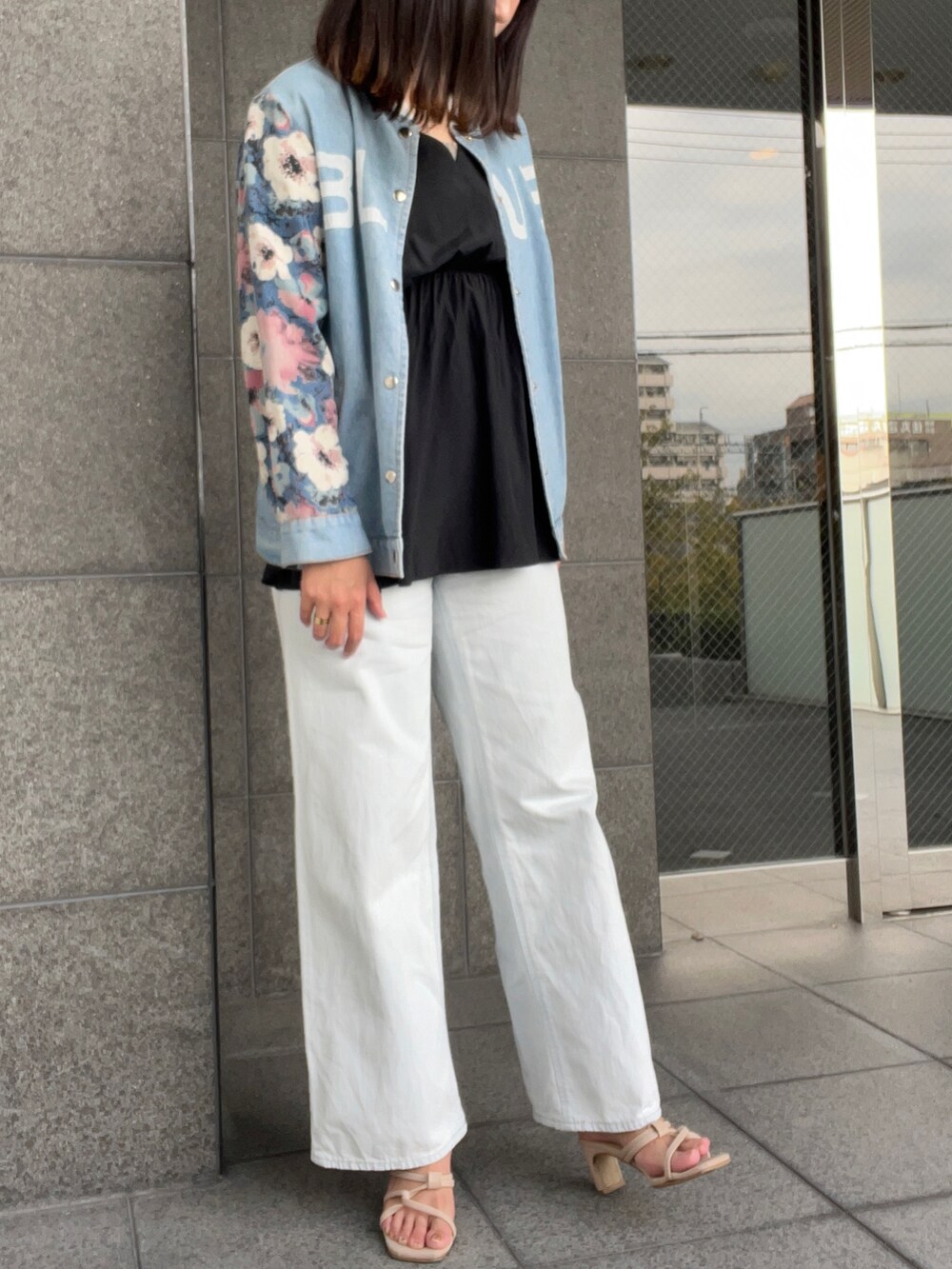 ブラック系のシャツ/ブラウス、ブルー系のデニムジャケット、ブルー系のデニムパンツを着用したレディースの秋コーディネートの2枚目の写真