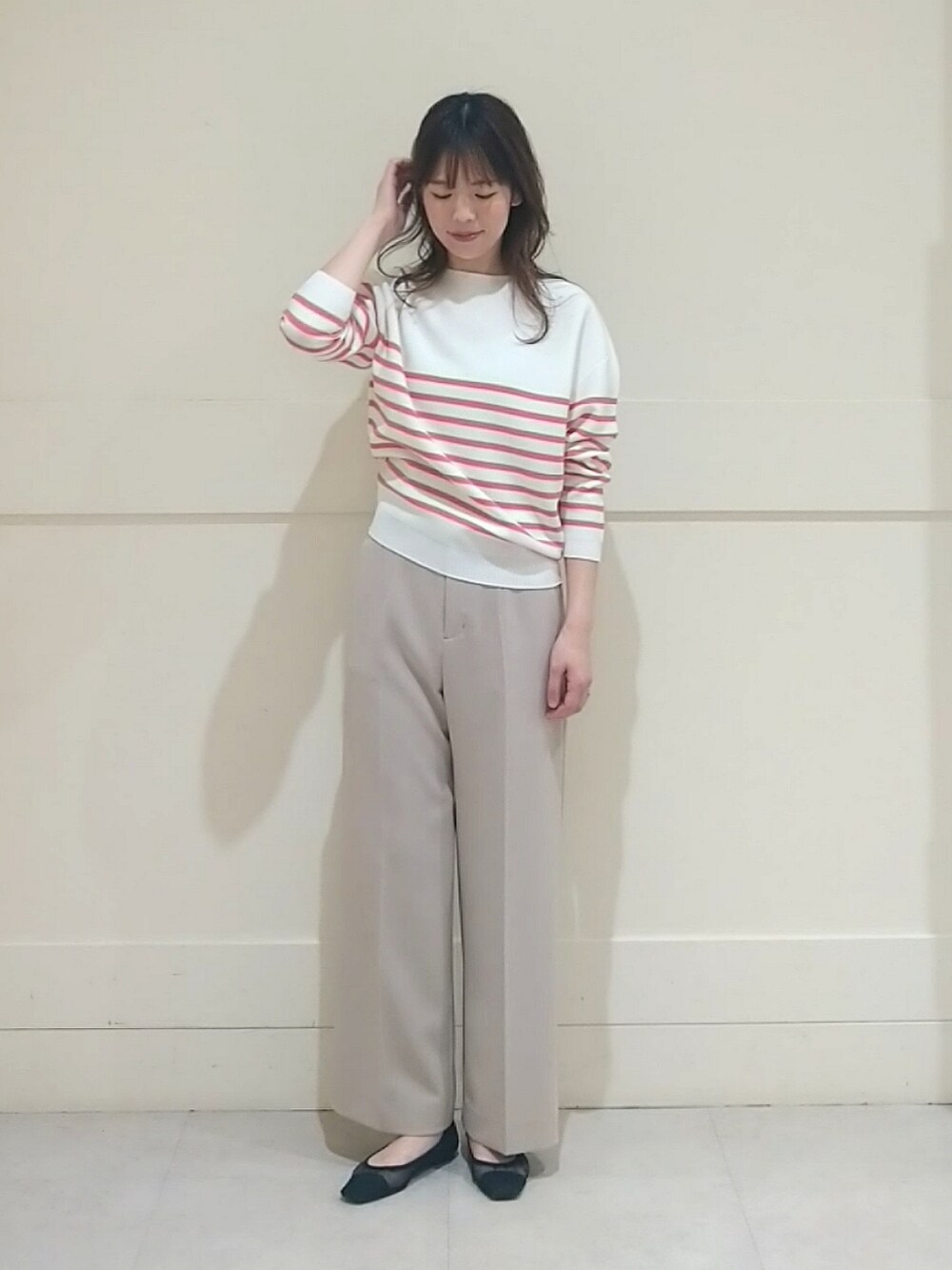 オレンジ系のニット/セーター、ベージュ系のその他パンツ、その他のその他を着用したレディースの春コーディネートの2枚目の写真