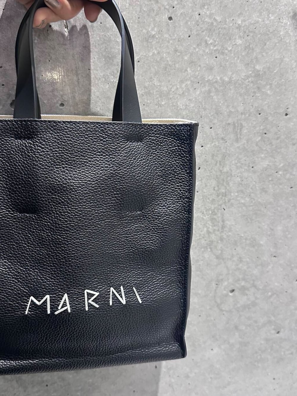 ブルー系のブーツ、ブラック系のニット/セーター、グレー系のスカートを着用したレディースの冬コーディネートの6枚目の写真