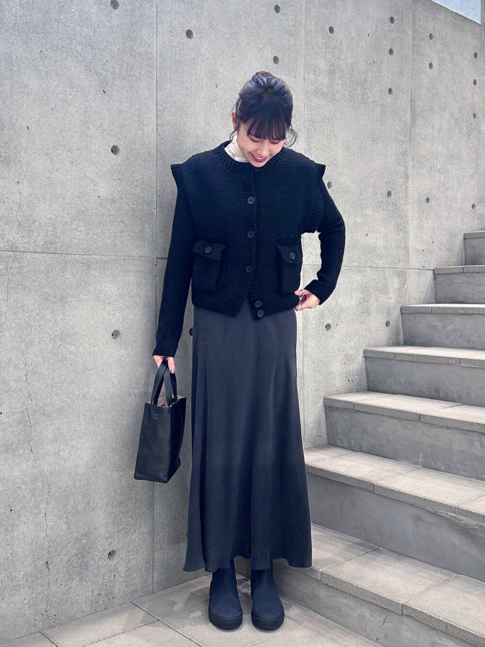 ブルー系のブーツ、ブラック系のニット/セーター、グレー系のスカートを着用したレディースの冬コーディネートの2枚目の写真