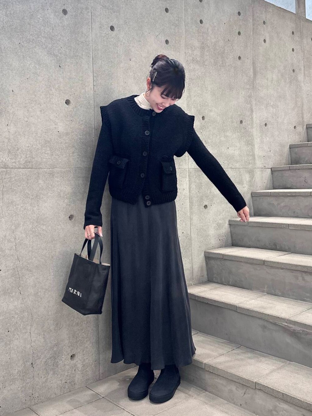 ブルー系のブーツ、ブラック系のニット/セーター、グレー系のスカートを着用したレディースの冬コーディネートの4枚目の写真