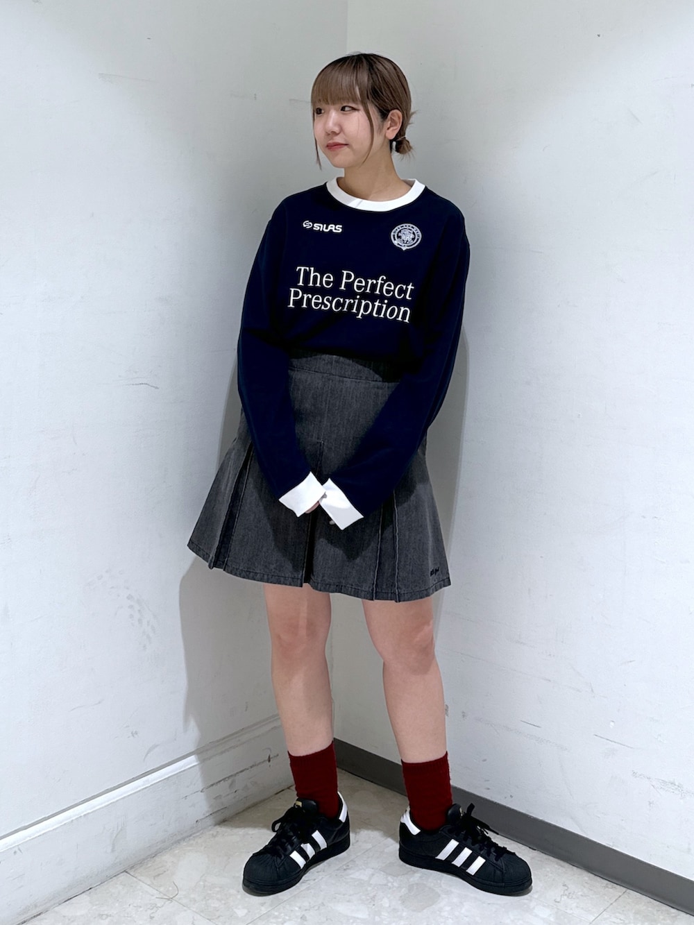 ブラック系のバックパック/リュック、ブルー系のTシャツ/カットソー、ブラック系のデニムスカートを着用したレディースの冬コーディネートの3枚目の写真