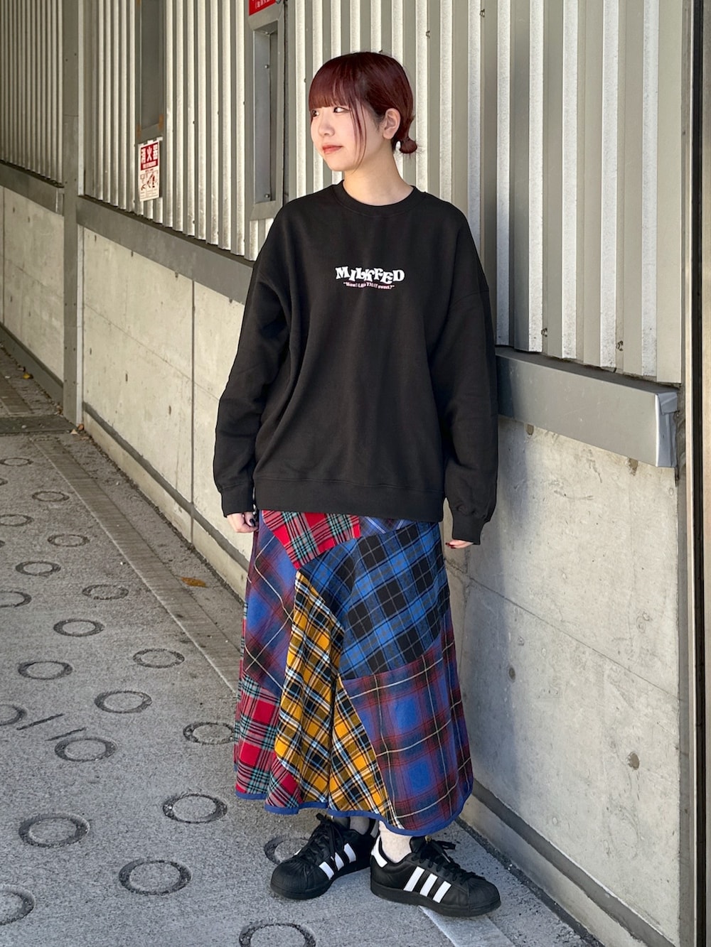 ブラック系のスウェット、ブラック系のダウンジャケット/コート、ブルー系のスカートを着用したレディースの冬コーディネートの3枚目の写真