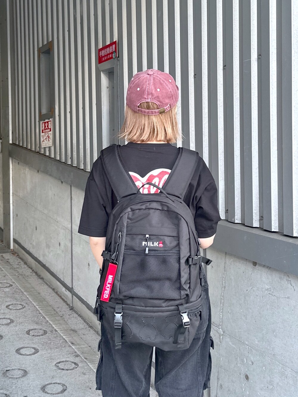 ブラック系のTシャツ/カットソー、ブラック系のカーゴパンツ、レッド系のキャップを着用したレディースの春コーディネートの3枚目の写真