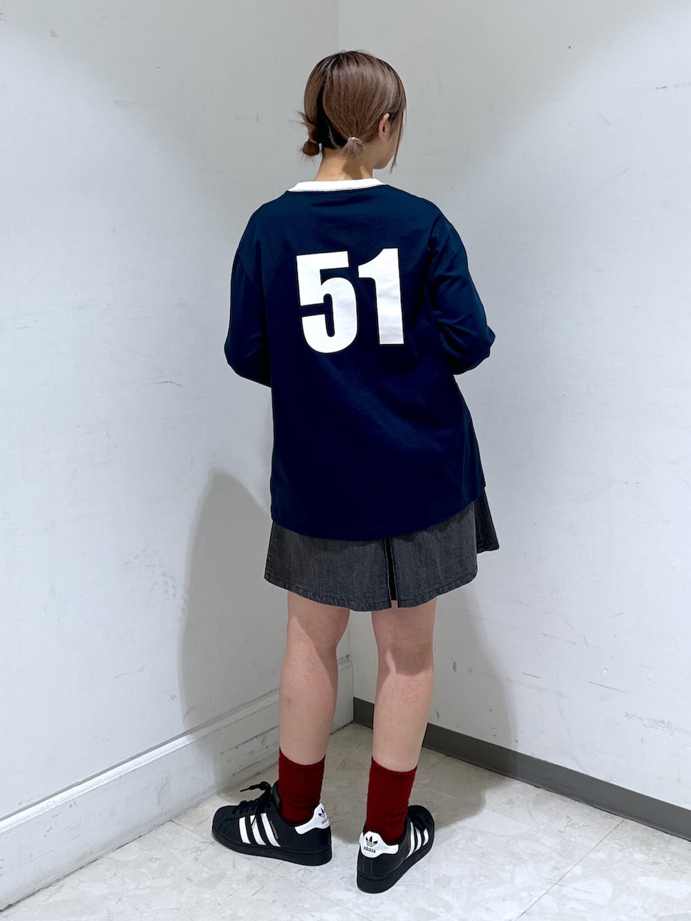 ブラック系のバックパック/リュック、ブルー系のTシャツ/カットソー、ブラック系のデニムスカートを着用したレディースの冬コーディネートの4枚目の写真