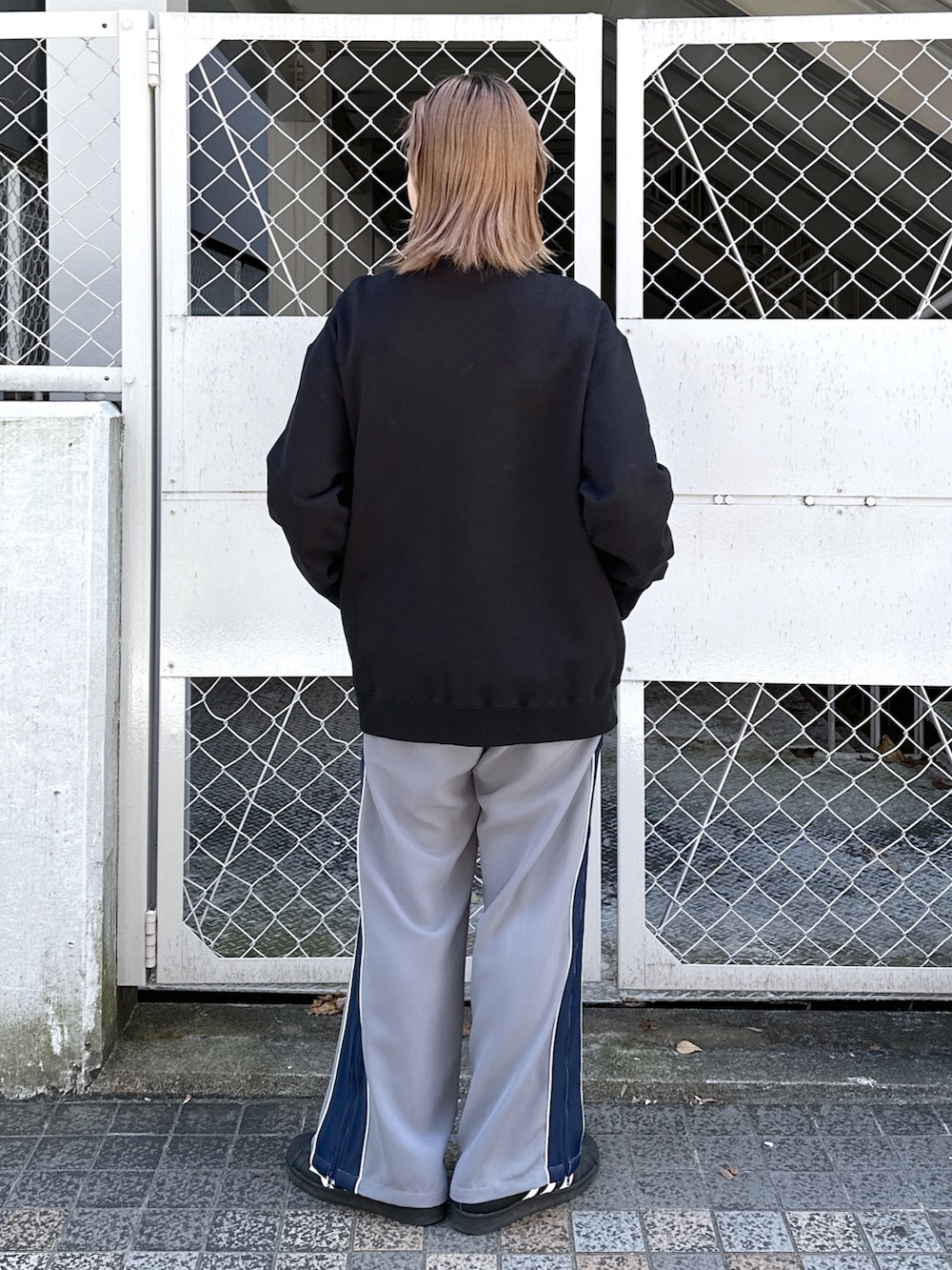 ブラック系のスウェット、グレー系のその他パンツ、グリーン系のメッセンジャーバッグを着用したレディースの春コーディネートの4枚目の写真