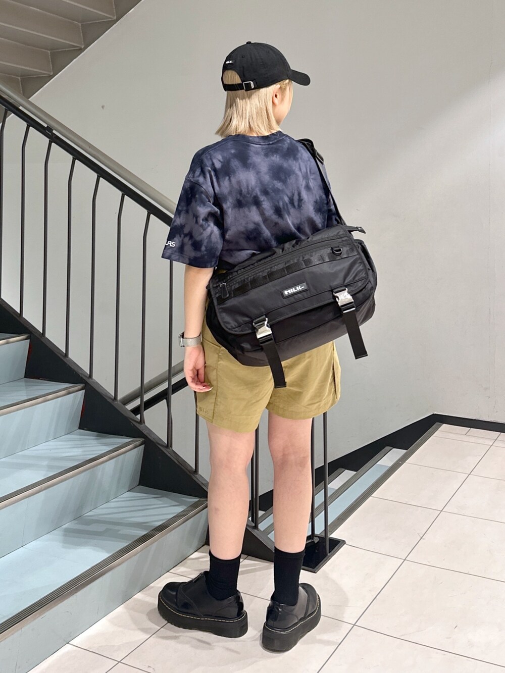 ブラック系のTシャツ/カットソー、ベージュ系のその他パンツ、ブラック系のメッセンジャーバッグを着用したレディースの春コーディネートの2枚目の写真